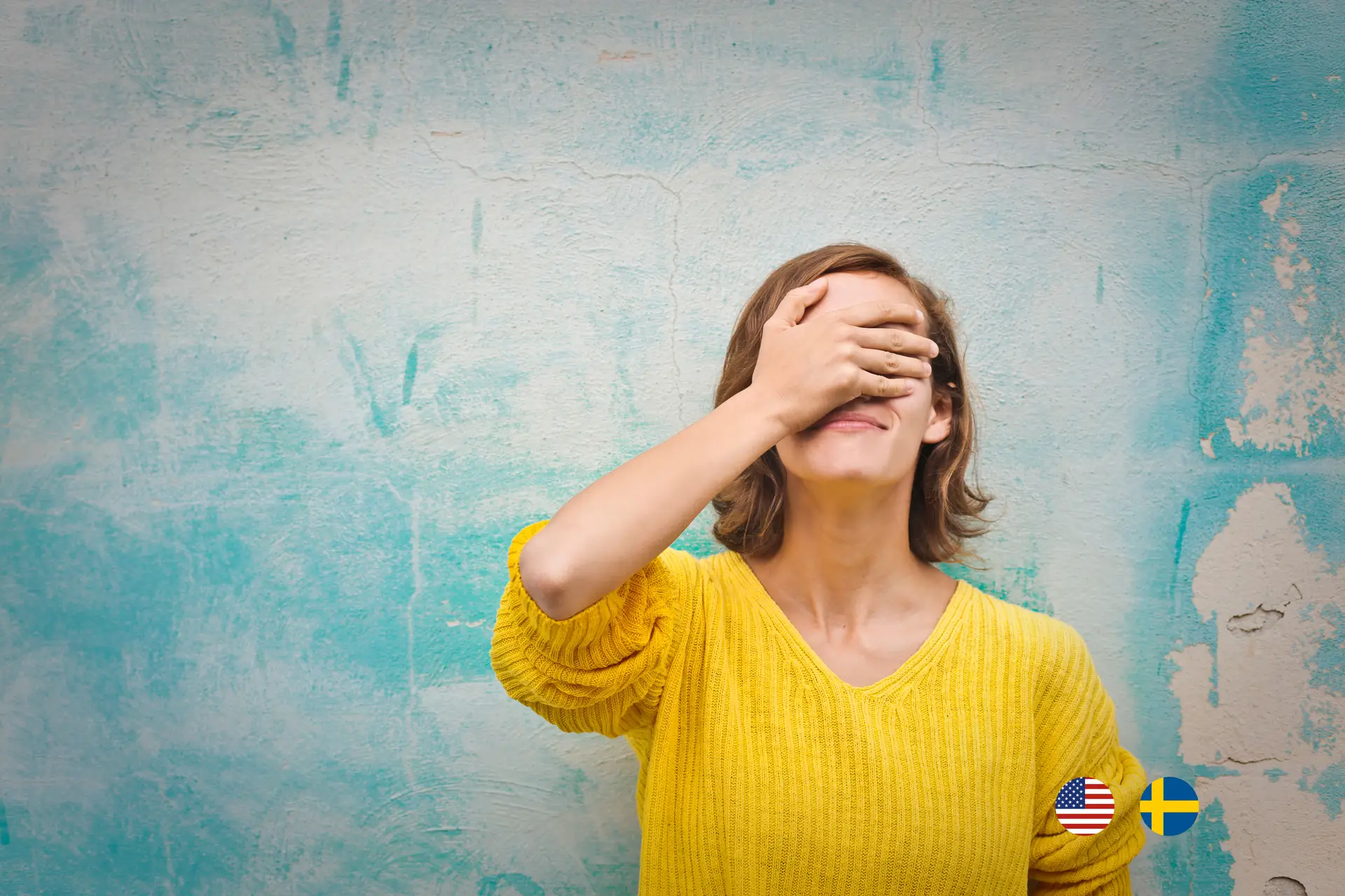 Woman standing with her back against a wall with her hand over her face because of a mistake she did.