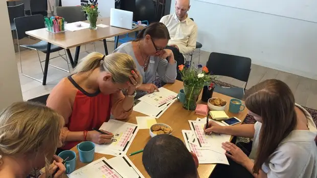 A team sitting together around a workspace co-developing digital services together